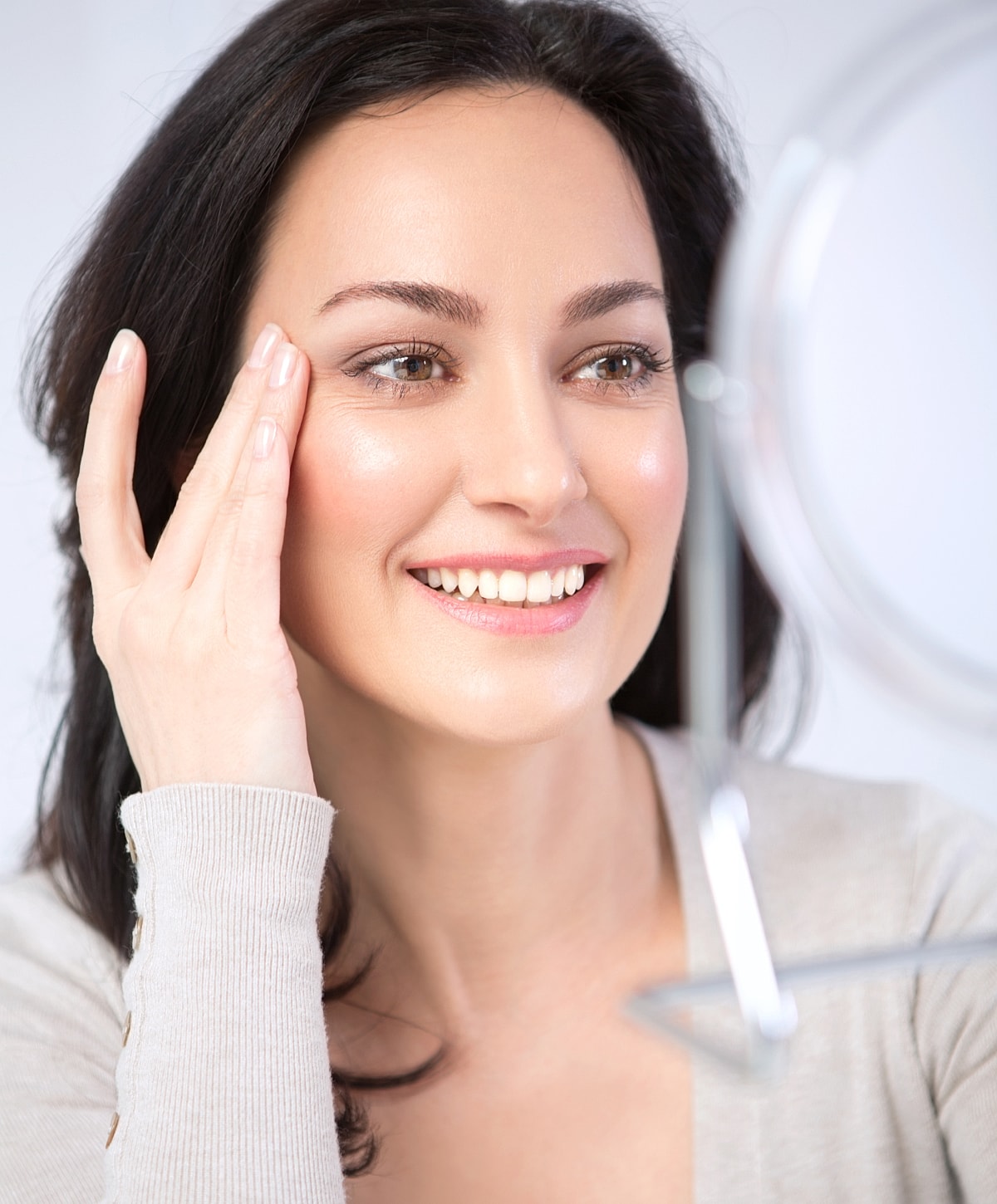 Woman smiling in front of a mirror.
