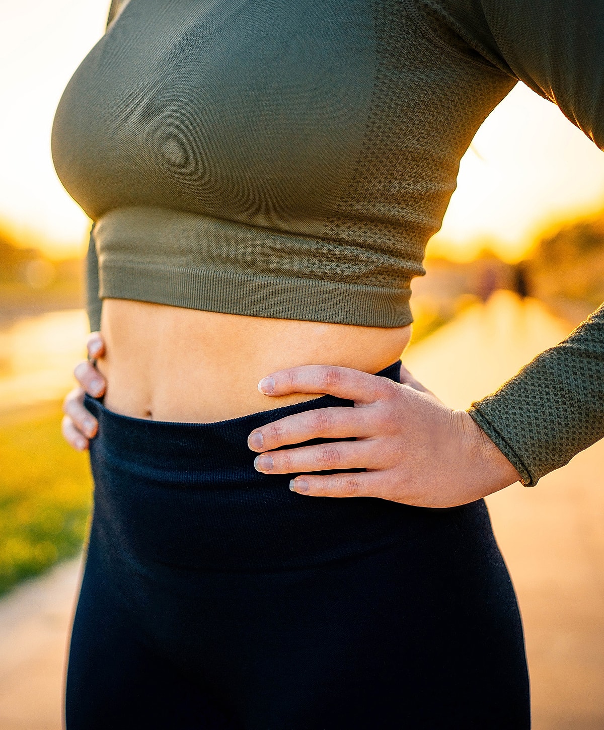 Woman in athletic wear with sunset background.