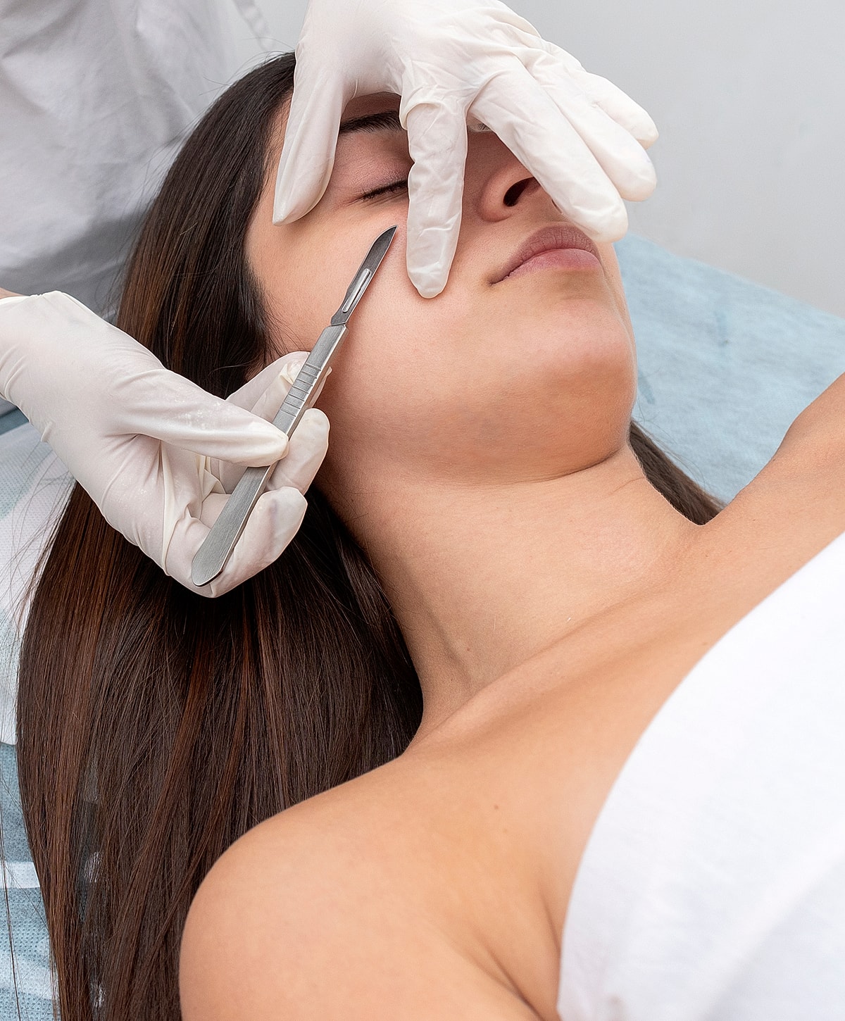 Facial treatment with a scalpel on a patient.