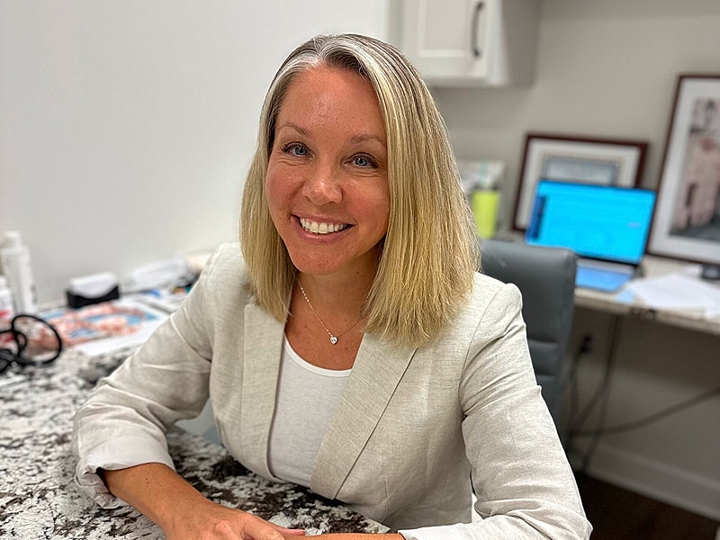 Smiling woman in professional office setting.