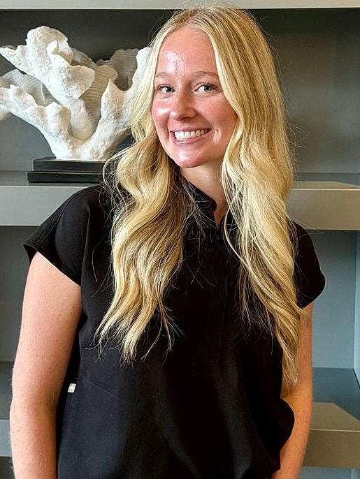 Smiling woman with long blonde hair, black shirt.