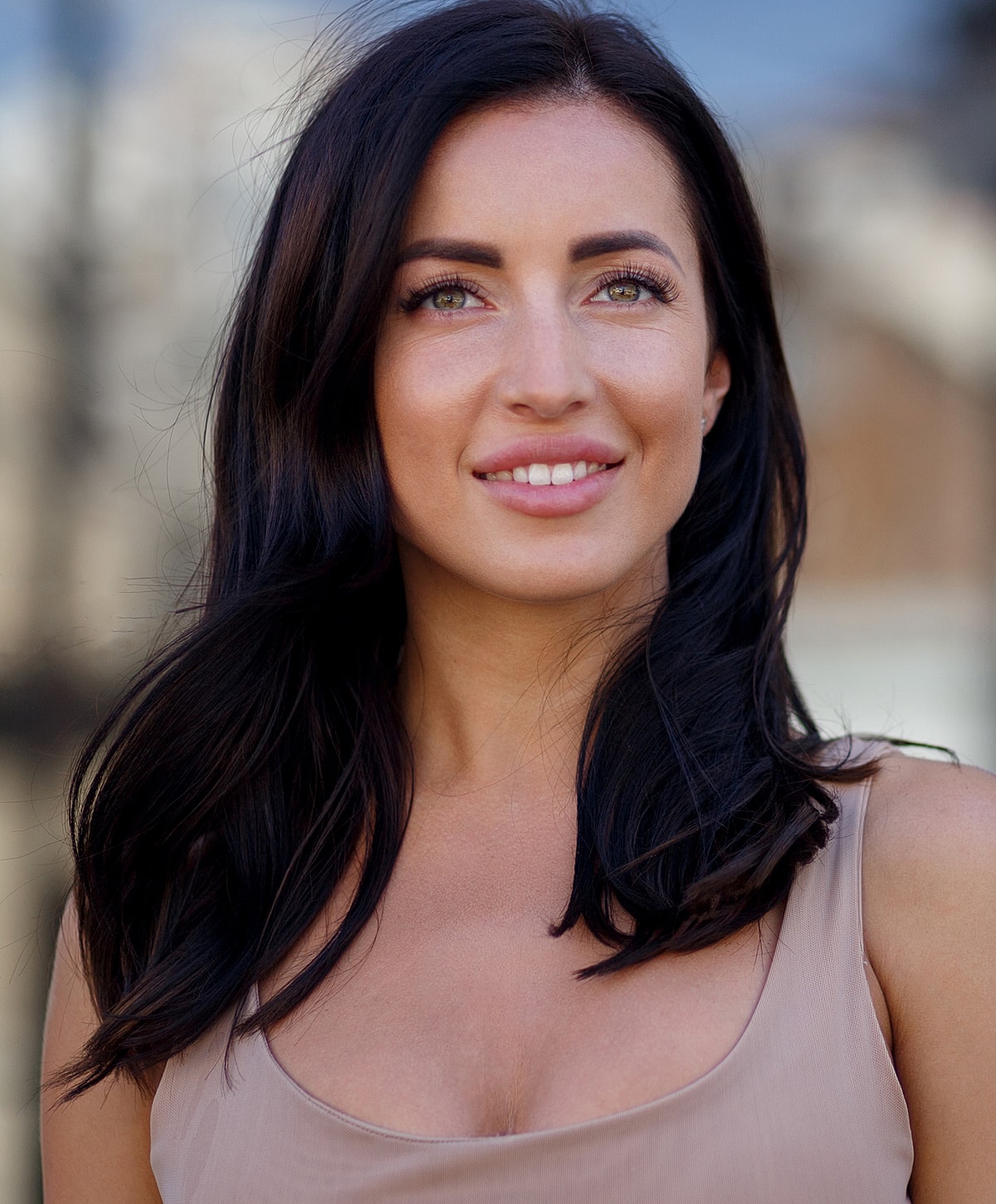 Woman smiling in natural outdoor setting.