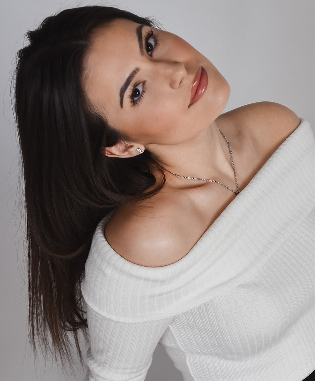 Woman with long hair in off-shoulder top.