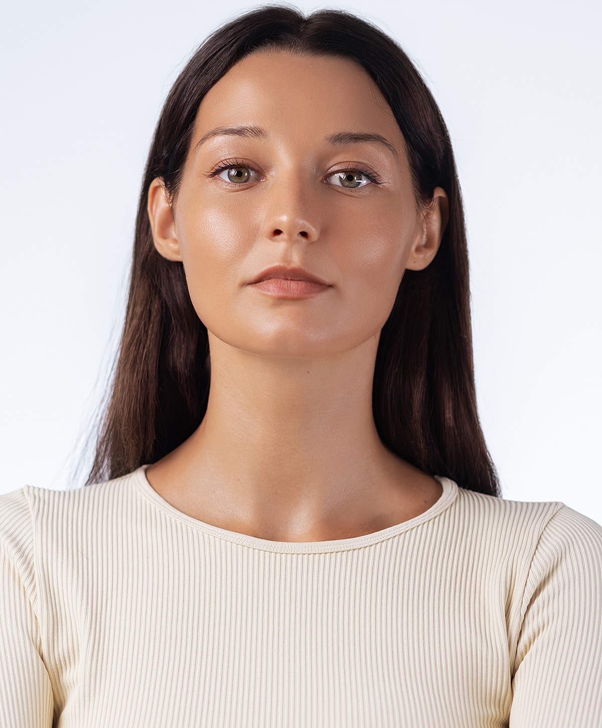 Woman with long hair in neutral shirt against backdrop