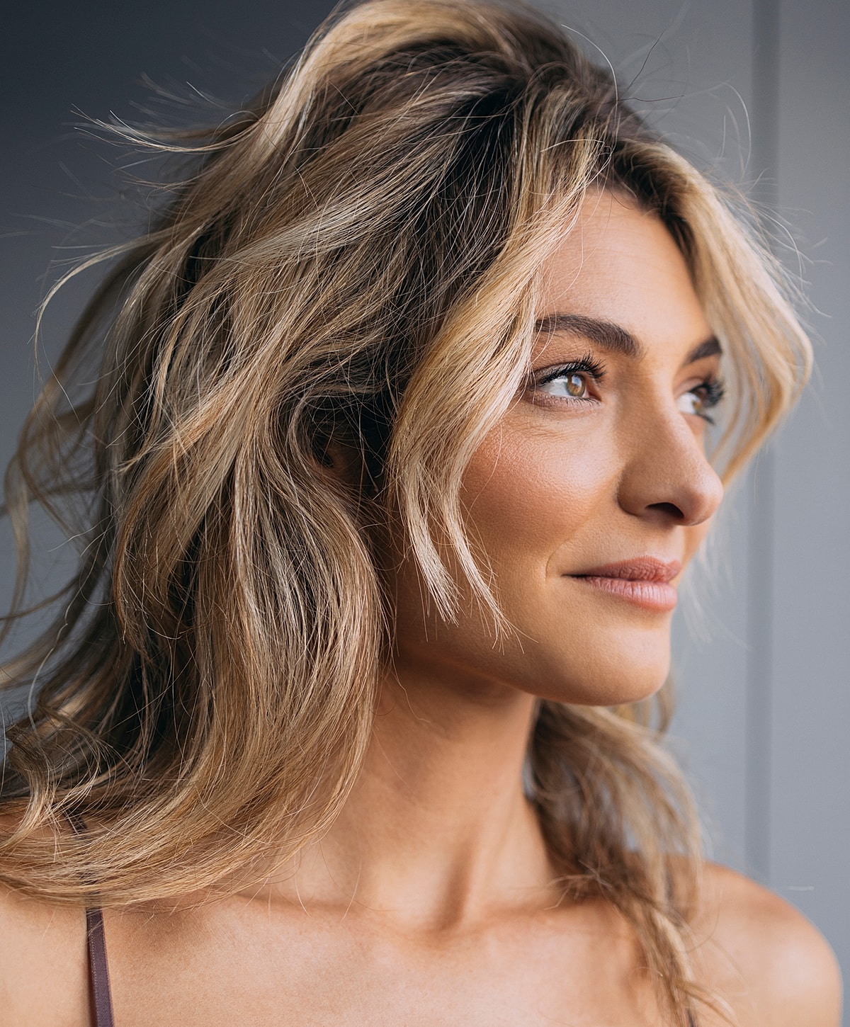 Woman with long, wavy hair and serene expression.
