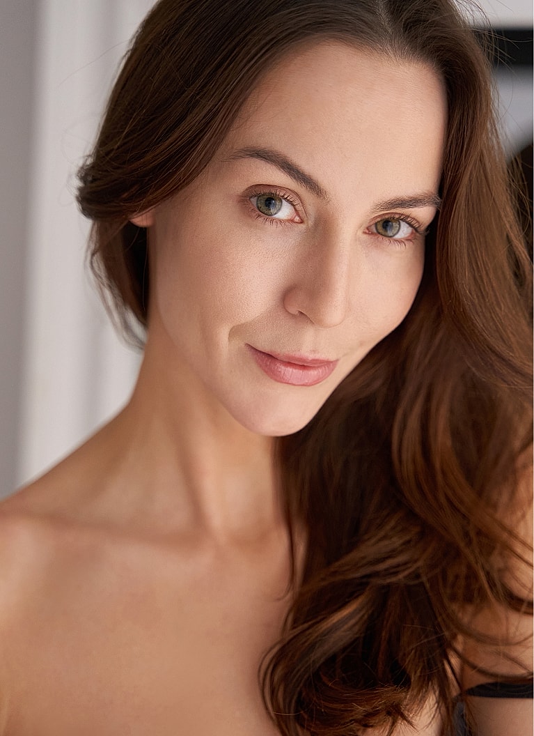 Woman in black outfit with soft expression.