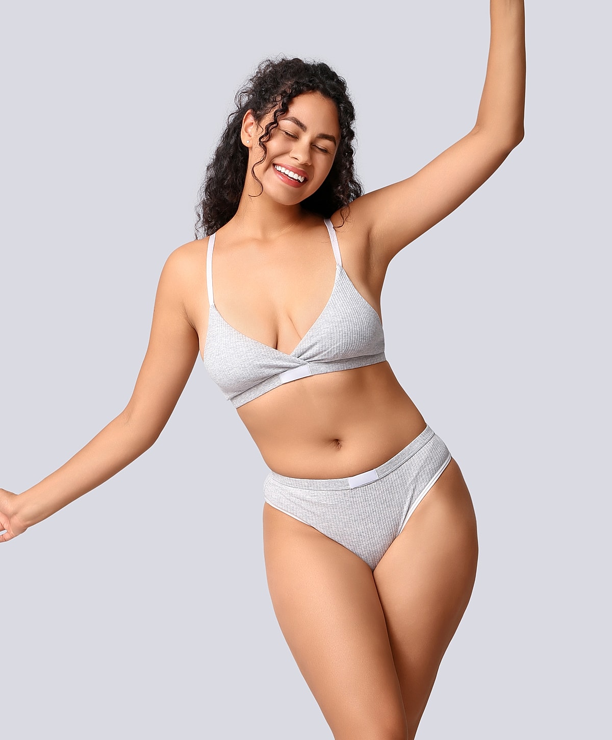 Smiling woman in gray bikini poses playfully.