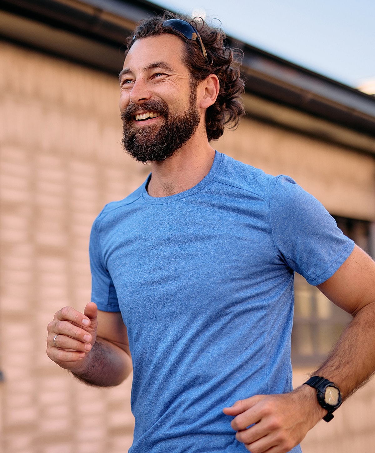 Man jogging with a smile in blue shirt.