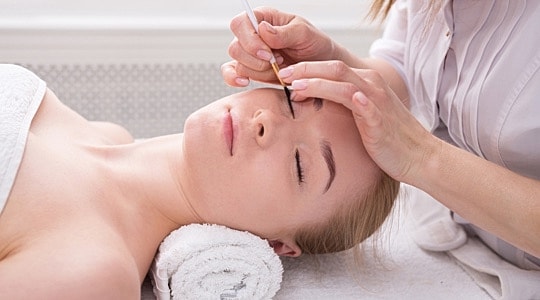Woman receiving an eyelash tint service at a medspa