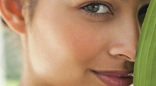 Woman partially obscured by a green leaf.