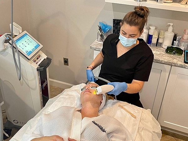 Woman receiving facial treatment in spa setting.