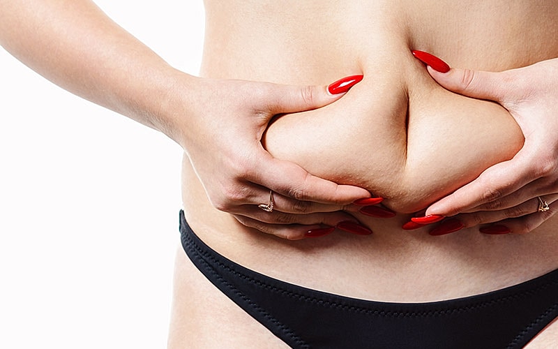 Hands on midsection, emphasizing body positivity.