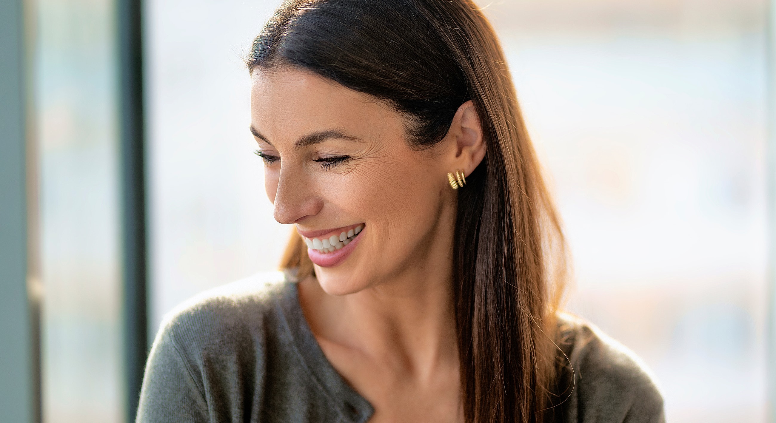 Smiling woman in a cozy indoor setting.
