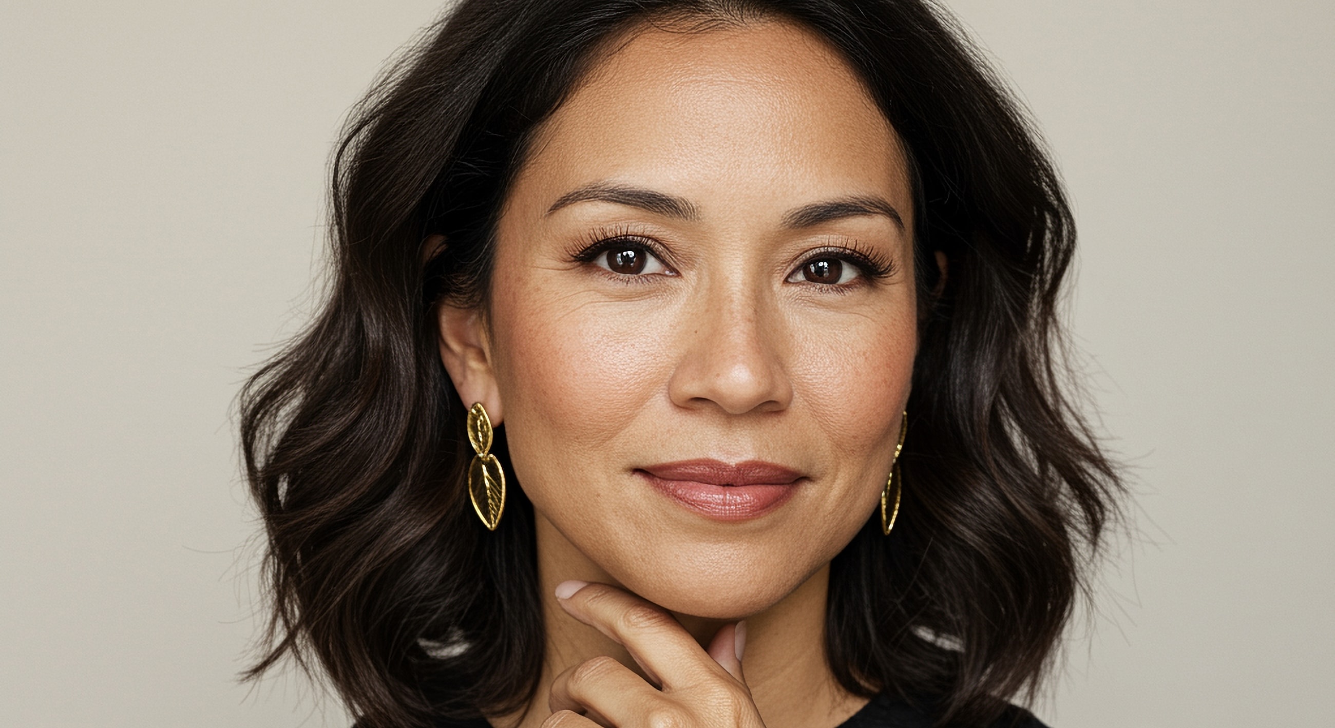 Woman with elegant earrings and thoughtful expression.
