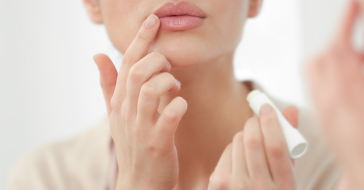Applying lip balm in front of a mirror.
