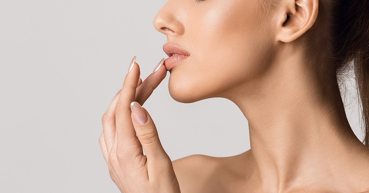 Profile of a woman touching her mouth.