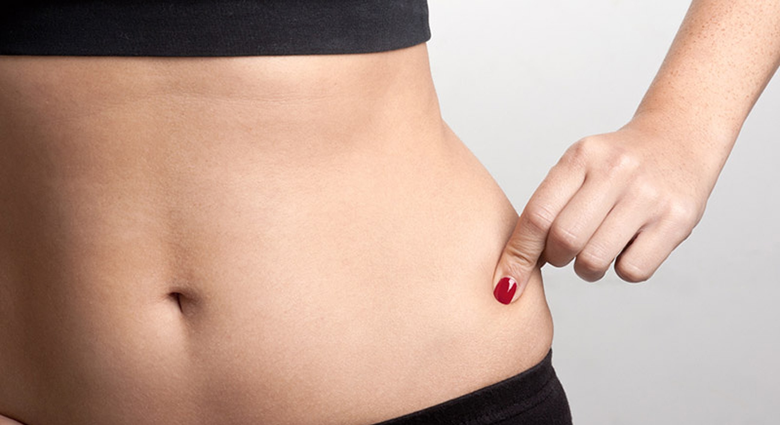 Woman touching her waist with red nail polish.